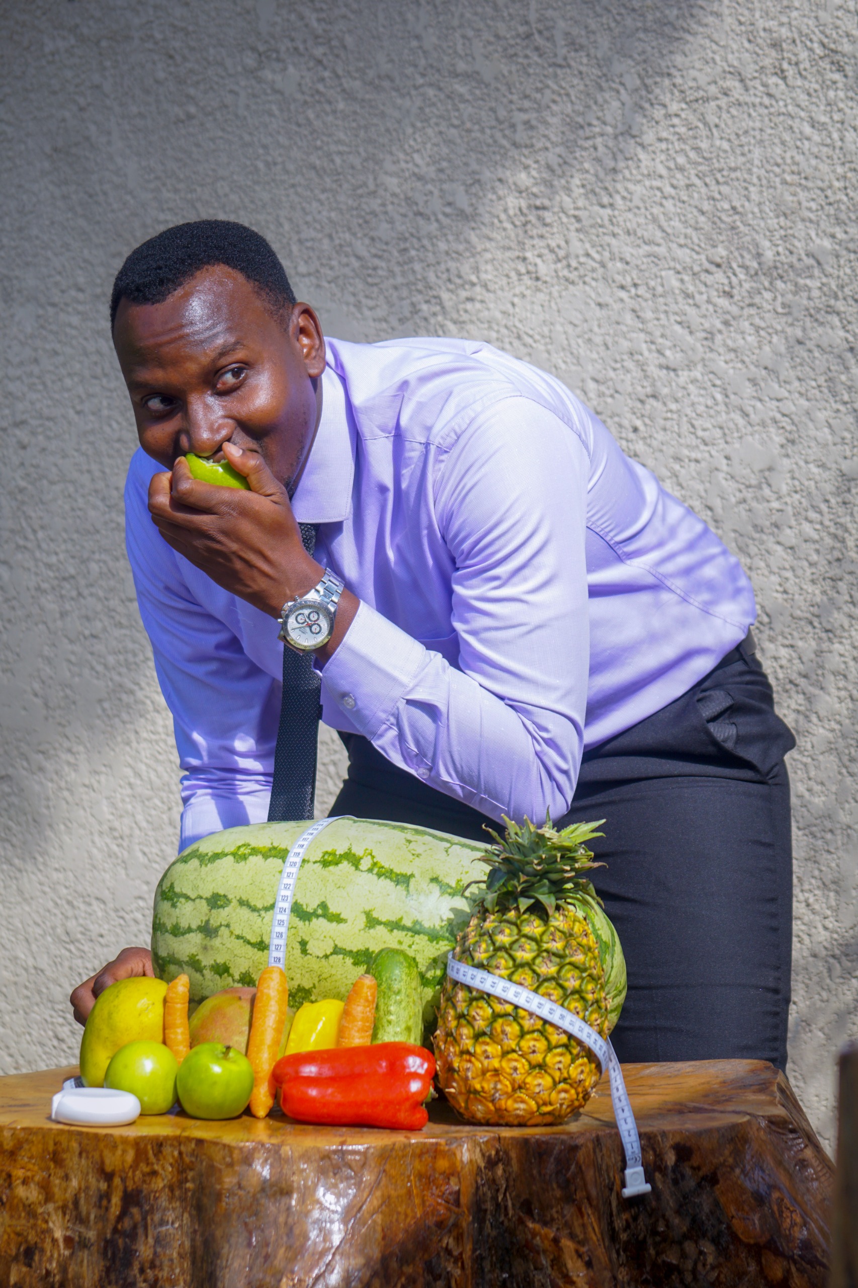 Ivan enjoying a fresh apple beside a spread of produce